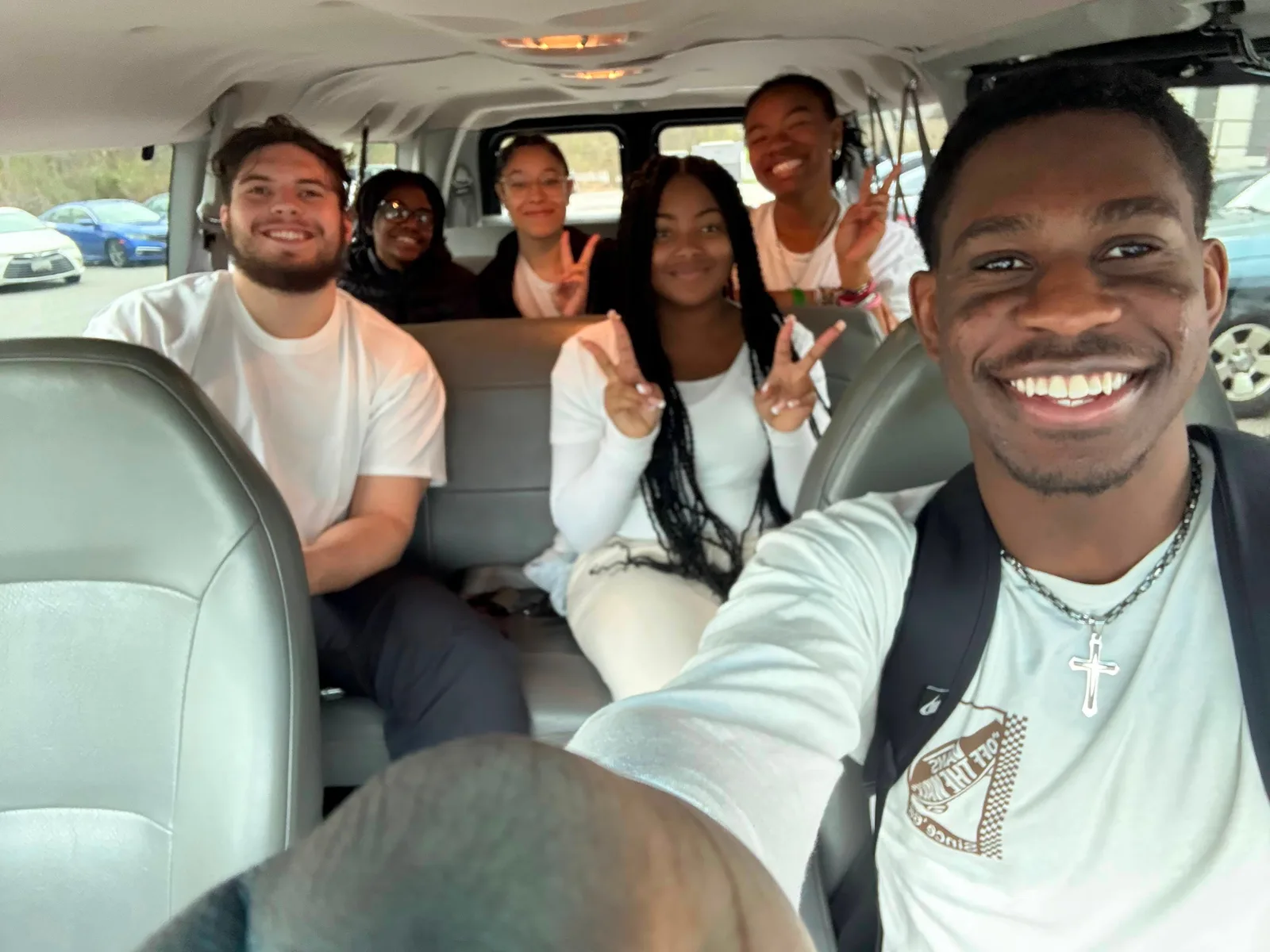 Six students in a van, turned back towards the camera.